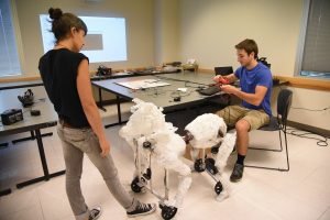 WSU Tri-Cities fine arts professor Sena Clara Creston and engineering student Gordan Gavric work on the "Huminal," an interactive robot that responds to its environment.