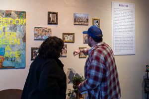 Professor Robert Franklin pointing out an art piece on the wall to a guest.