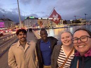 Anna Plemons, Zoe Pfeifer, Romeo Ross, and Barghav Iyer posing for a photo in front of a Swiss flag.