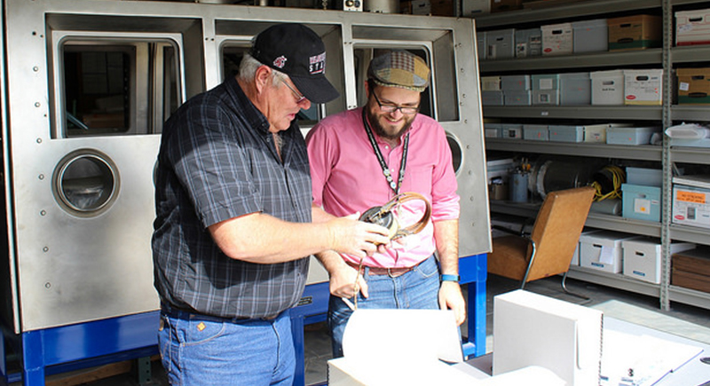 Wyatt Wineinger, son of the pilot of the Day’s Pay, turns over artifacts from the Day's Pay and his father, Arlys Wineinger, to WSU Tri-Cities