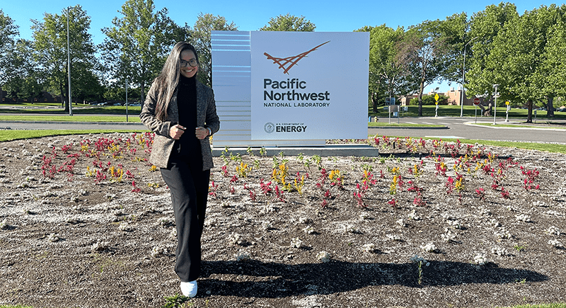 Maria Paula Garcia-Tovar standing in front of a Pacific Northwest National Laboratory sign.