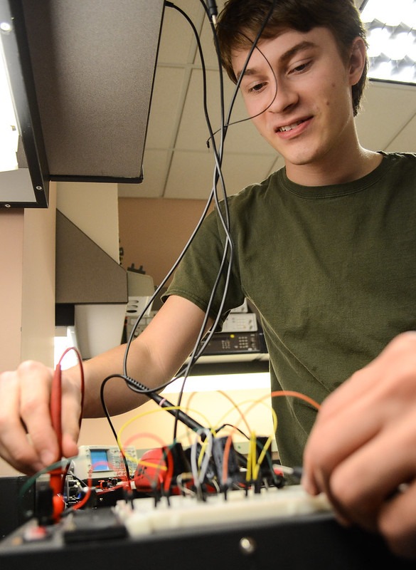 Student working on a circuit board.