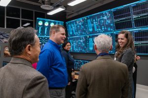 WSU faculty and staff having a conversation in front of large computer monitors.