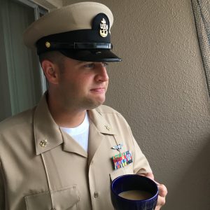 Jeff Wilson in Navy uniform holds a mug of coffee.