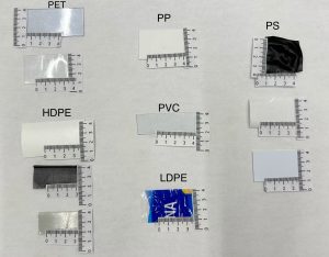Plastic samples on a piece of paper with the following labels, PET, PP, PS, HDPE, PVC, LDPE.