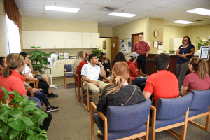 Group of students sit and listen to presentation at health clinic