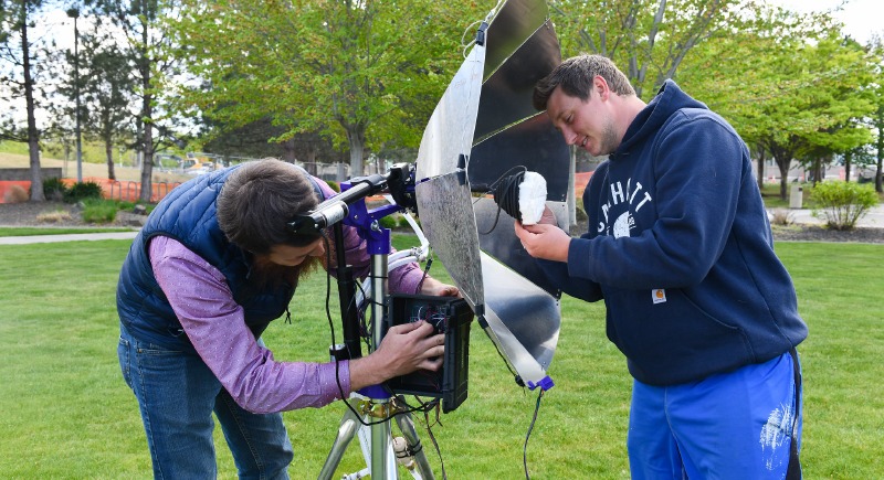 Engineering students Mitch Blocher (left) and Zack Garcia set-up the the solar water purifier they designed and built as part of their senior design class this spring.