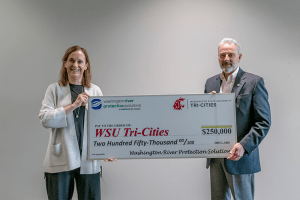 WSU Tri-Cities chancellor Sandra Haynes and president of WRPS John Eschenberg hold a check for $250,000