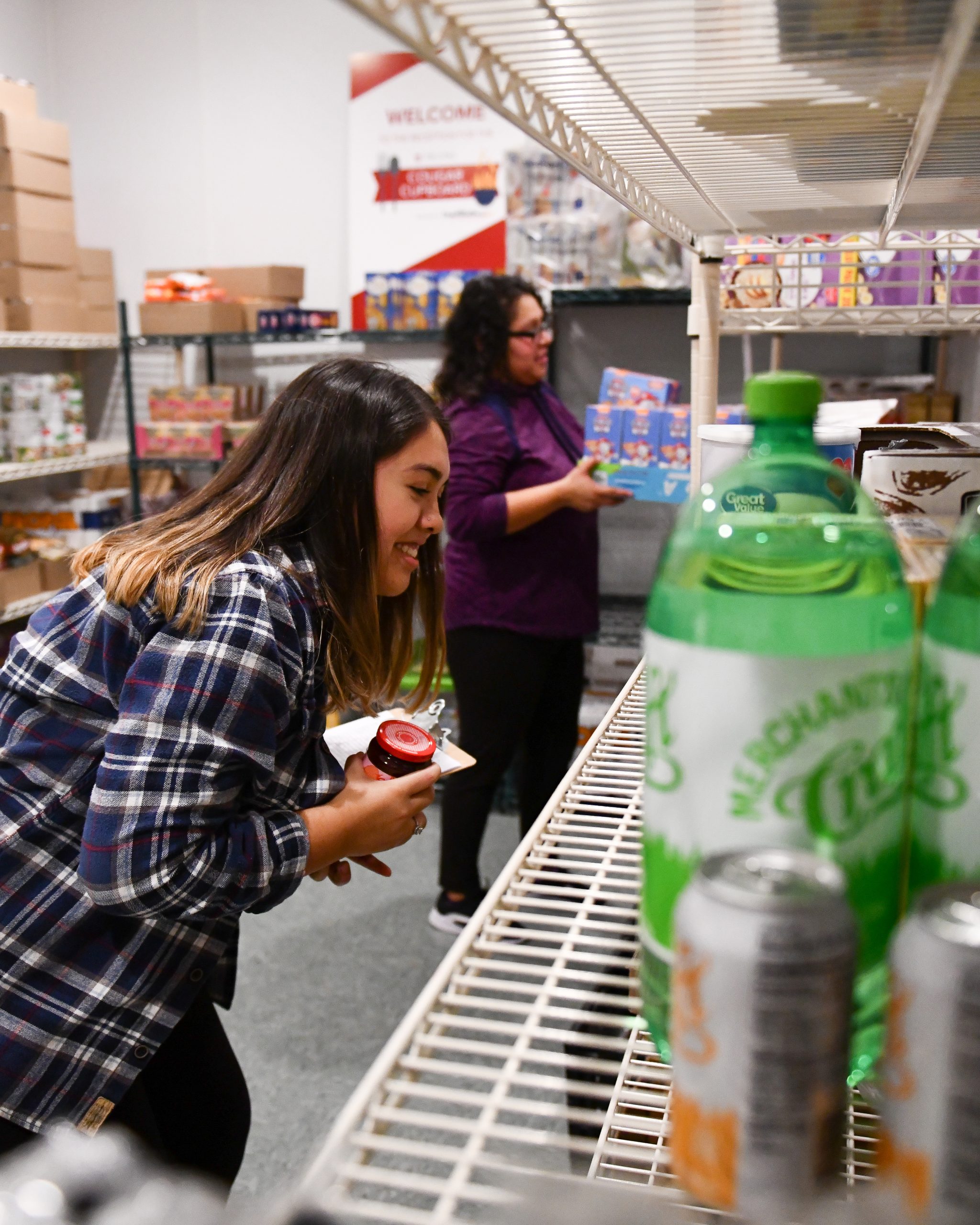 Students placing canned food on shelves.