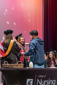 Maria Valle and her son smiling on stage.