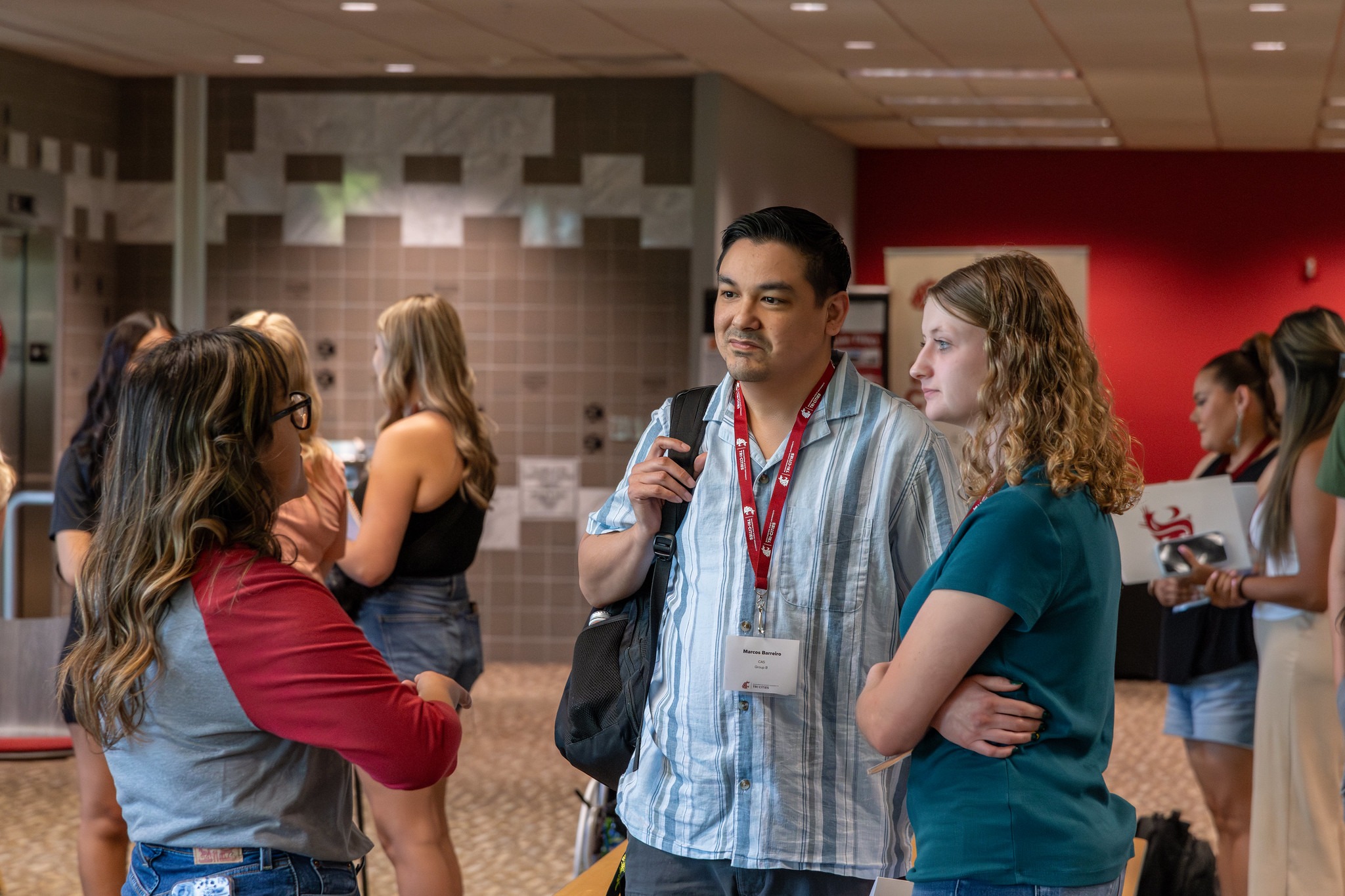 Two students speaking with a WSU Tri-Cities staff member.