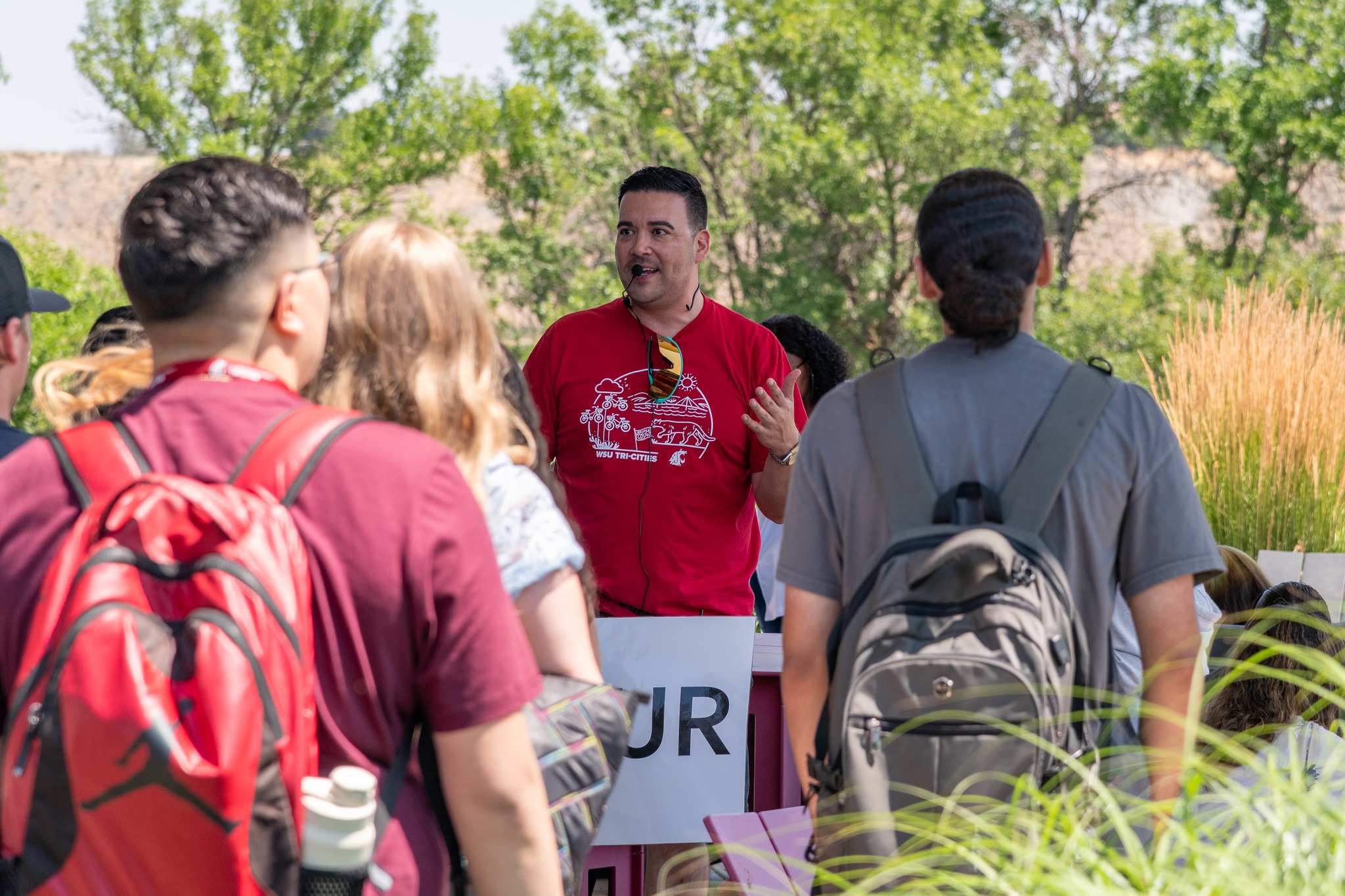 WSU Tri-Cities staff member with a microphone giving students a tour.