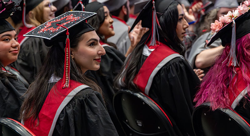 WSU Tri-Cities student Yasamin Alazawi wearing regalia seated at a commencement ceremony.